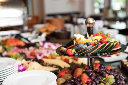 a table with a tray of fruit on a plate at Hotel am See in Grevesmühlen