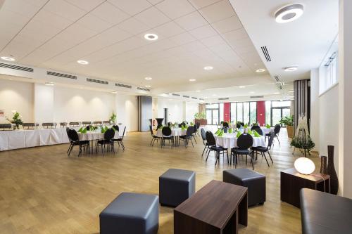 a large banquet hall with tables and chairs and people at Hotel am See in Grevesmühlen
