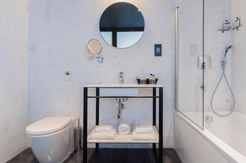 a bathroom with a sink and a toilet and a mirror at La Falconeria Hotel in Valletta