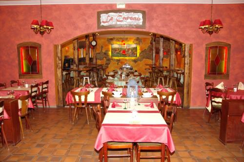 a restaurant with tables and chairs and pink walls at La Table Alsacienne in Farébersviller