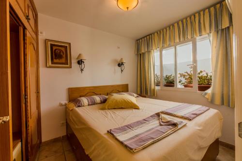 a bedroom with a large bed with a window at Casa Charlotte in Nerja