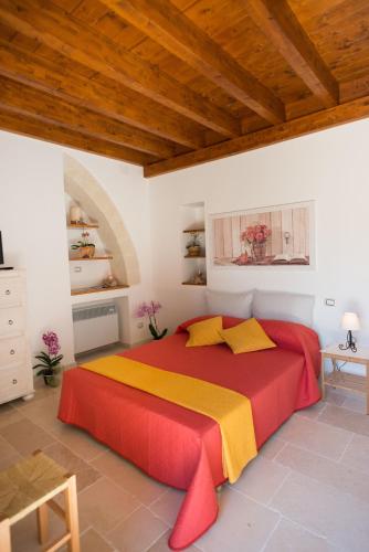 a bedroom with a large red and yellow bed at Grandi Trulli Bed & Breakfast in Alberobello