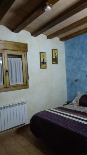 a bedroom with a bed and a wooden cabinet at Rural Las Campanas in Torremocha del Pinar