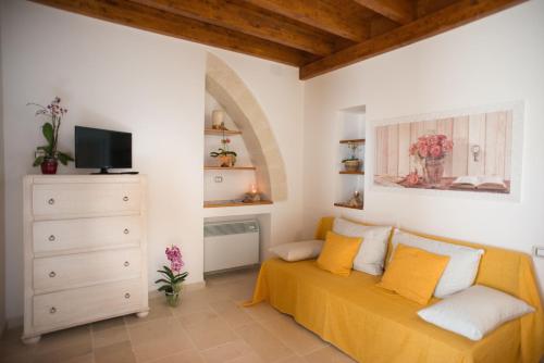 sala de estar con sofá y TV en Grandi Trulli Bed & Breakfast, en Alberobello