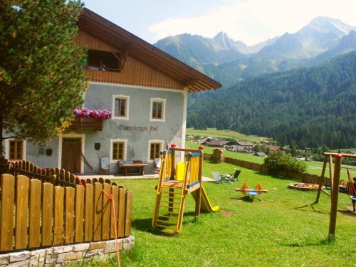 a yard with playground equipment in front of a house at Unterbergerhof in Val di Vizze