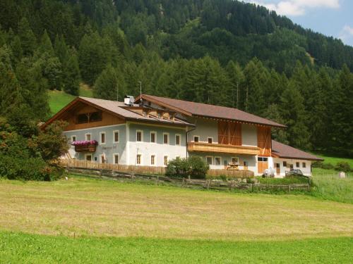a large house in the middle of a field at Unterbergerhof in Val di Vizze