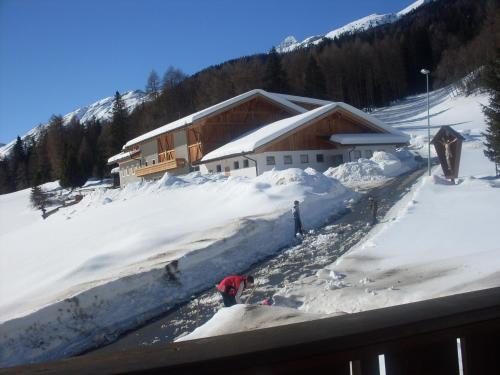 a ski lodge with a pile of snow in front of it at Unterbergerhof in Val di Vizze