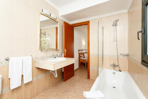 馬貝拉的住宿－安達盧茲普韋布洛全球酒店，带浴缸和盥洗盆的浴室