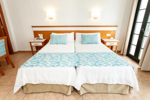 a hotel room with two beds and a table at Globales Pueblo Andaluz in Marbella