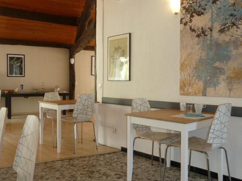 ein Esszimmer mit zwei Tischen und Stühlen in der Unterkunft Hôtel Vila in Frontignan