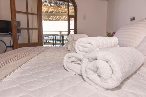 a bedroom with white towels on a bed at Poseidon Apartments in Tolo