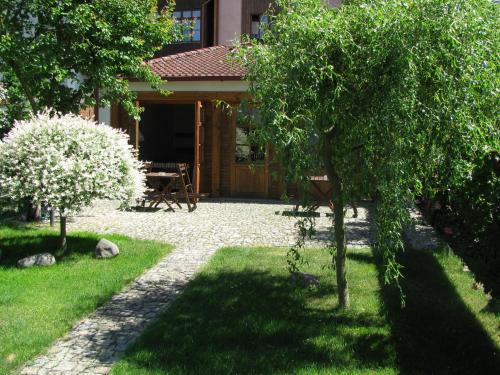 a house with a garden with trees in front of it at Penzion 102 in Pardubice