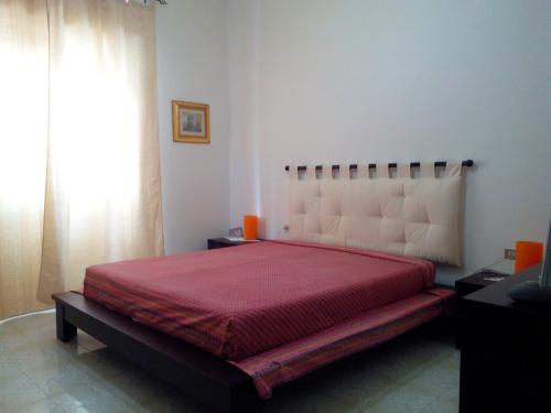 - une chambre avec un grand lit et une couette rouge dans l'établissement Appartamento Gianluca, à SantʼAntìoco