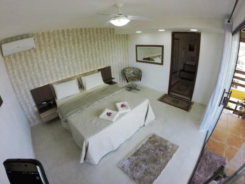 una vista sul soffitto di una camera da letto con un letto e un tavolo di Pousada da Baleia a Rio das Ostras
