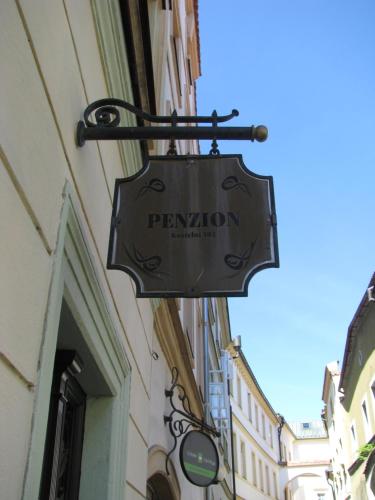 a sign for a restaurant hanging on the side of a building at Penzion 102 in Pardubice