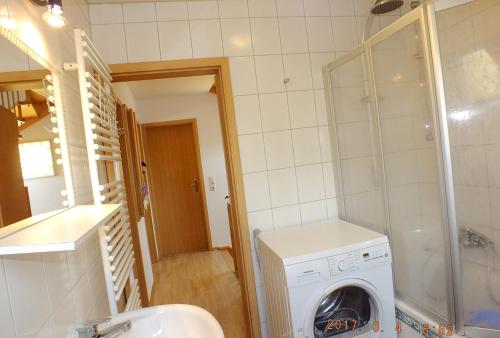 a bathroom with a washing machine and a washer at Familienfreundliches Ferienhaus AMARA mit Garten und Terrasse - Friedrichshafen am Bodensee in Friedrichshafen