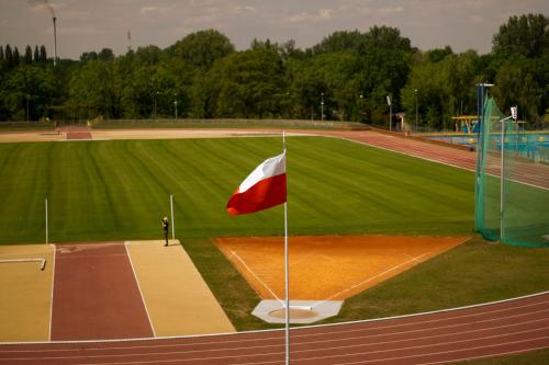 a person standing on a baseball field with a red and white flag at Hotel Olimpik Park in Słubice
