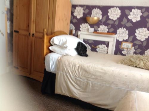 a bedroom with two beds and a wall with flowers at Sherwood Lodge in Skegness