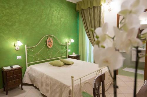 zieloną sypialnię z łóżkiem i zielonymi ścianami w obiekcie B&B Le due gioie w mieście Taviano