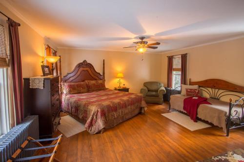 1 dormitorio con 1 cama grande y 1 silla en Snow Goose Bed and Breakfast, en Keene Valley