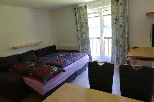 ein Wohnzimmer mit einem Sofa, einem Tisch und einem Fenster in der Unterkunft Urlauben im Grünen in Fuschl am See