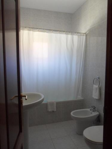 La salle de bains est pourvue d'une baignoire, d'un lavabo et de toilettes. dans l'établissement Casa Da Veiga, à Gerês