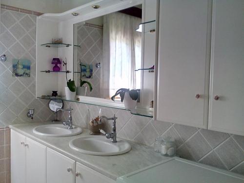 a bathroom with two sinks and a mirror at Villa Rose Garden in Agios Ioannis