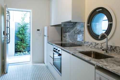 eine Küche mit einem Waschbecken und einem Spiegel in der Unterkunft Oporto Serviced Apartments - Alvares Cabral in Porto