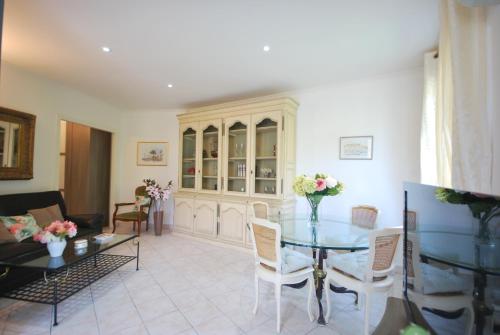 un salon avec une table en verre et des chaises dans l'établissement 2 Chambres Palais Justinia, à Cannes
