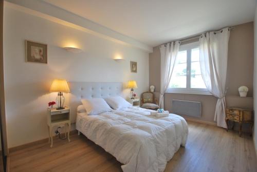 カンヌにある2 Chambres Palais Justiniaのベッドルーム(大きな白いベッド1台、窓付)