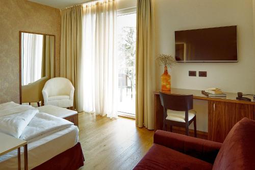 Habitación de hotel con cama y escritorio en Hotel Campagnola, en Bardolino