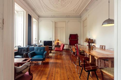 ein Wohnzimmer mit einem großen Holztisch und Stühlen in der Unterkunft Independente Príncipe Real in Lissabon