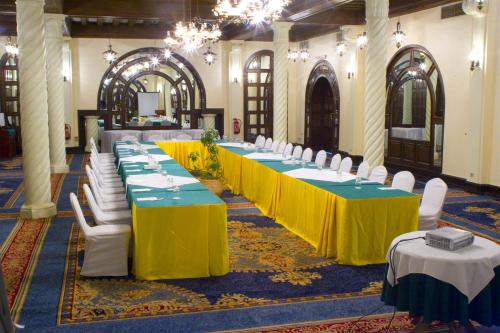 a row of tables in a large room with white chairs at Helnan Auberge Fayoum in Fayoum Center