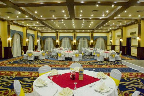 a large banquet hall with white tables and chairs at Helnan Auberge Fayoum in Fayoum Center