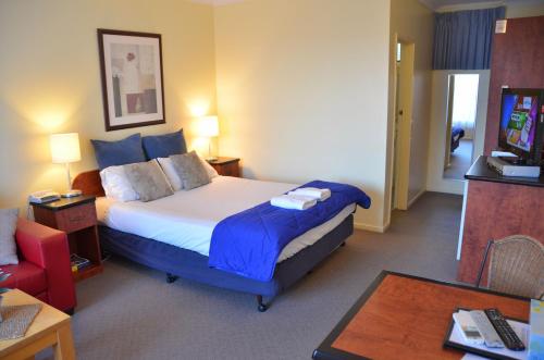 a hotel room with a bed and a television at The Sandridge Motel in Lorne