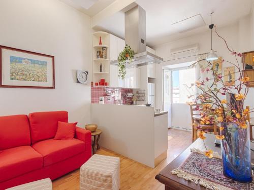 ローマにあるMatilda's Apartmentのリビングルーム(赤いソファ付)、キッチン