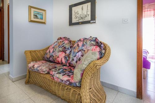 un sofá de mimbre en una sala de estar en Apartments Borghese, en Pula