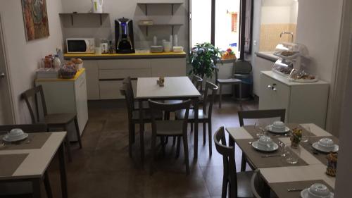 een keuken en eetkamer met tafels en stoelen bij BB Opera Dei Pupi in Siracusa