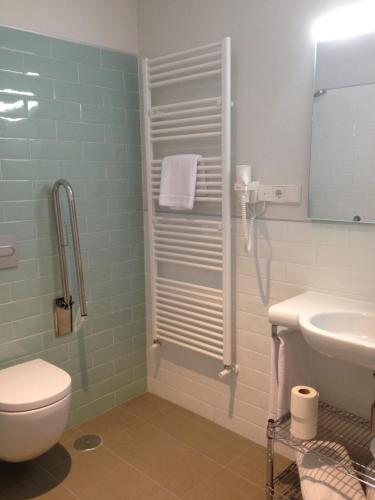 y baño con aseo y lavamanos. en San Lorenzo Suites, en San Lorenzo de El Escorial