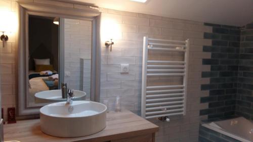 a bathroom with two sinks and a large mirror at Hotel Mendionde in Saint-Pée-sur-Nivelle