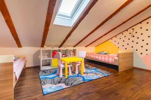 a childs room with a table and two beds at Apartment Lena in Rijeka