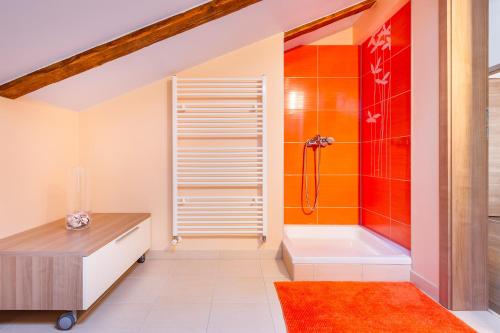 an attic bathroom with a shower and a tub at Apartment Lena in Rijeka