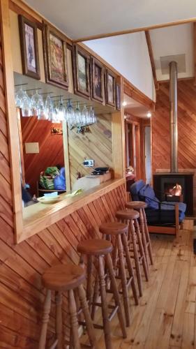 a bar with a row of stools in a room at Tatas Haus in Las Trancas