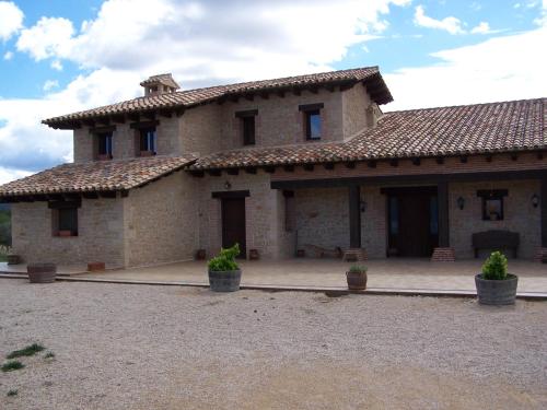 une grande maison en briques avec des plantes en pot devant elle dans l'établissement La Contrada, à Arens de Lledó