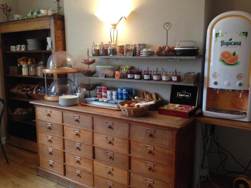 a kitchen with a wooden dresser with food on it at Contact Hotel Hôtel De Troyes in Troyes