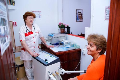 a woman standing in a room with a machine at Pensiunea JOJO in Băile Herculane