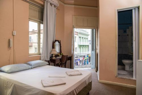 a bedroom with a bed with two towels on it at Hotel Palácio - Próx ao Hospital Santa Casa in Porto Alegre