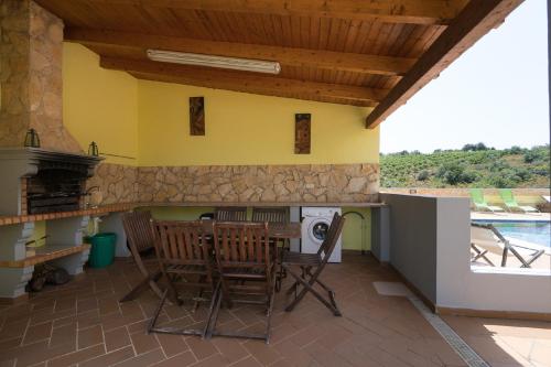 a patio with a table and chairs and a stove at Akivillas Pera Relax II in Alcantarilha