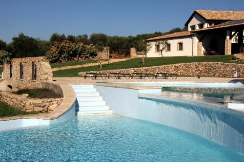 einem Pool mit blauem Wasser vor einem Gebäude in der Unterkunft Tenuta Corigliano in Rignano Garganico