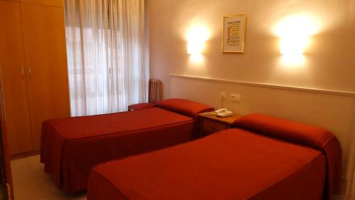 Habitación con 2 camas en una habitación de hotel en Hostal Atienzar, en Albacete